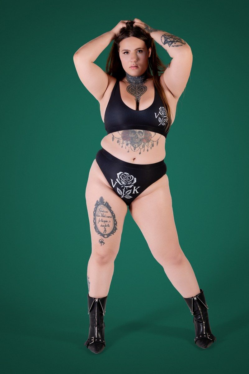 Before photo of @kenziehensenofficial, standing in a black two piece in front of a green studio backdrop.